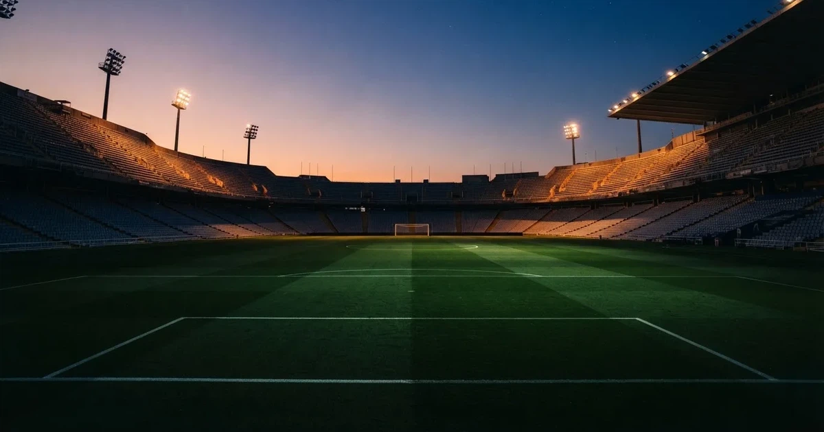 Een leeg voetbalstadion met lichtmasten bij schemering